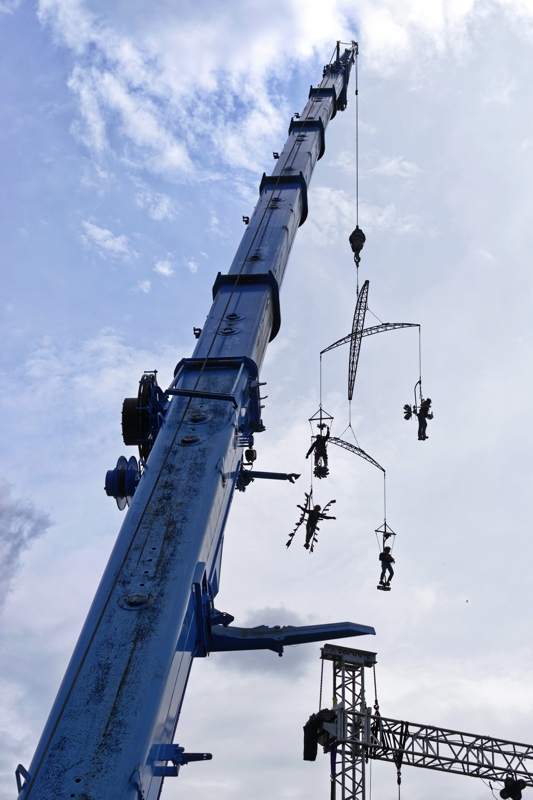 6 - A live acrobatic performance, likely for a show or film production, utilizing a large blue crane to suspend performers